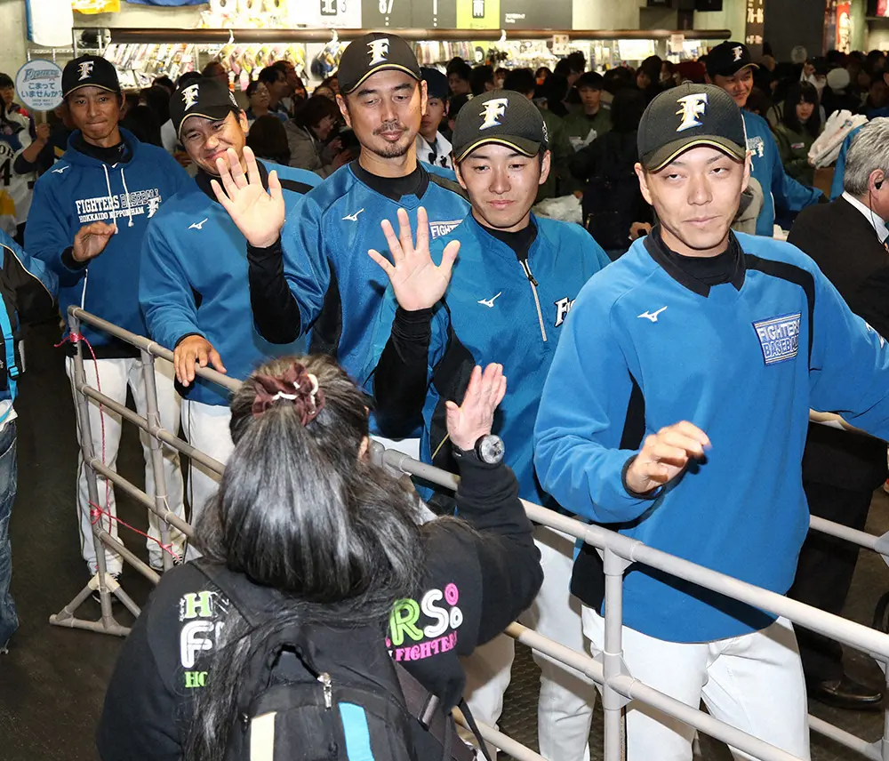 2017年3月、入場者をウェルカムハイタッチで出迎える（右から）日本ハムの宮西、斎藤、吉井コーチ、黒木コーチ、城石コーチ（肩書は当時）