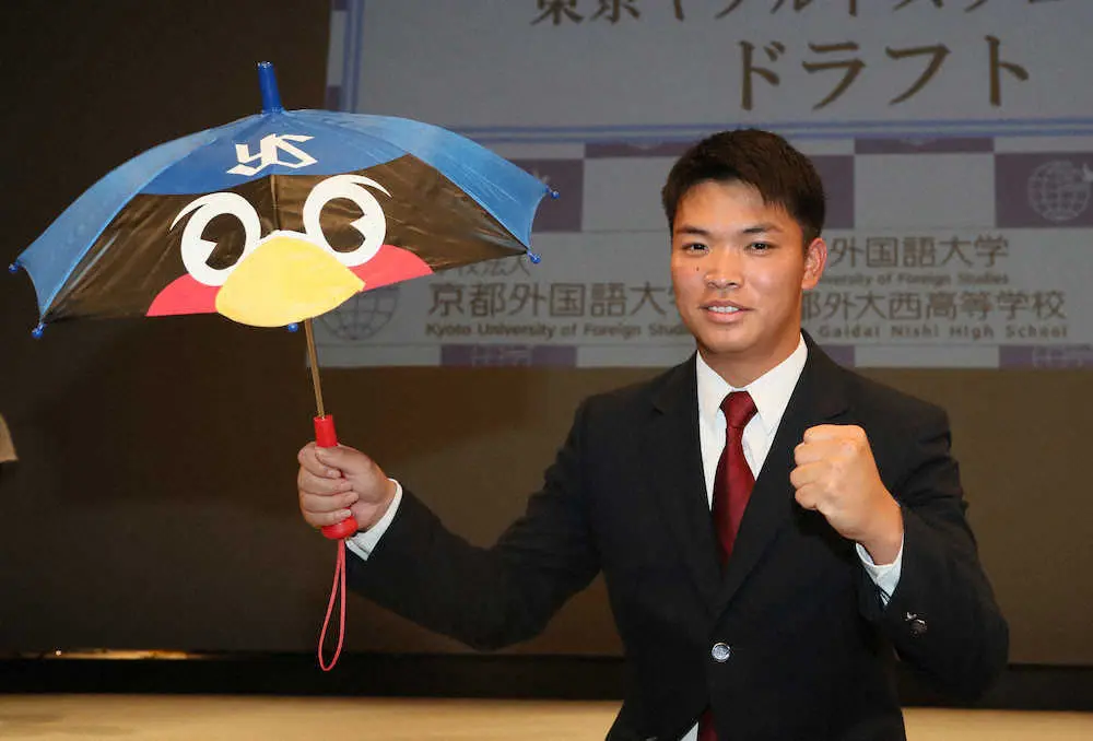 ヤクルトに2位指名され、つば九郎が描かれた傘を手にガッツポーズを決める京都外大西・西村瑠伊斗（撮影・岩崎　哲也）