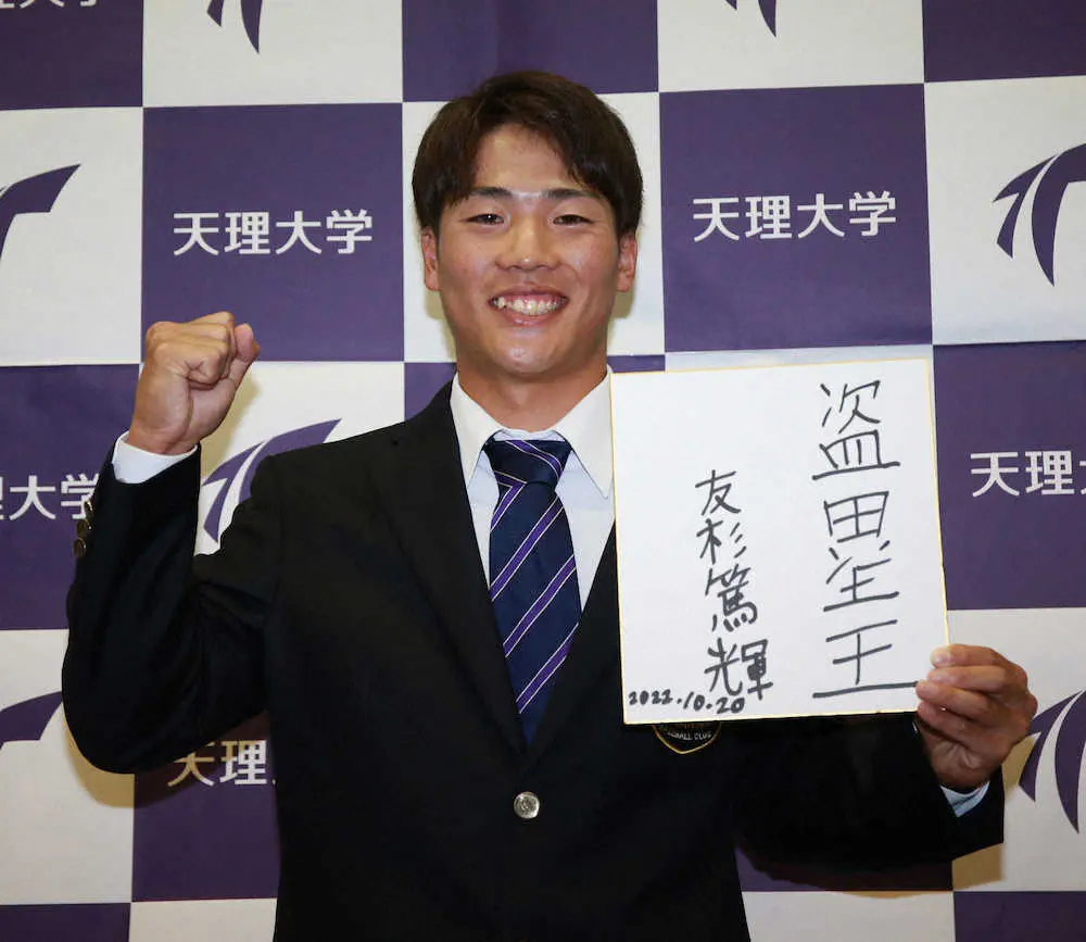 ロッテに2位指名された天理大・友杉篤輝は目標を書いた色紙を手に笑顔を見せる（撮影・奥　調）