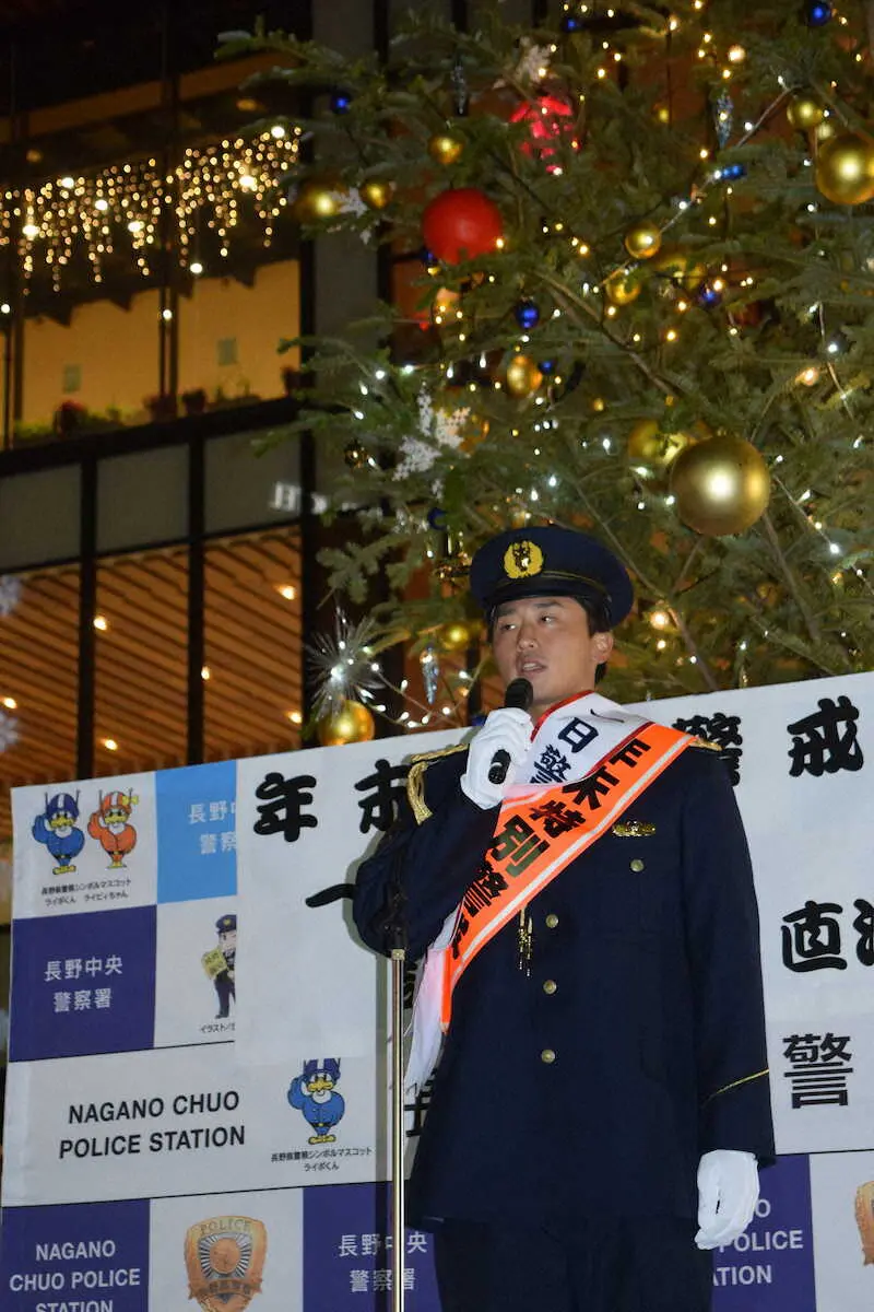1日警察署長を務めクリスマスツリーをバックにあいさつする巨人・直江