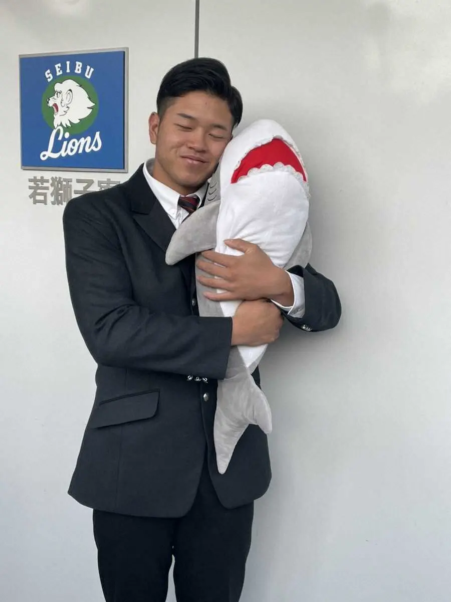サメの抱き枕を抱える野田