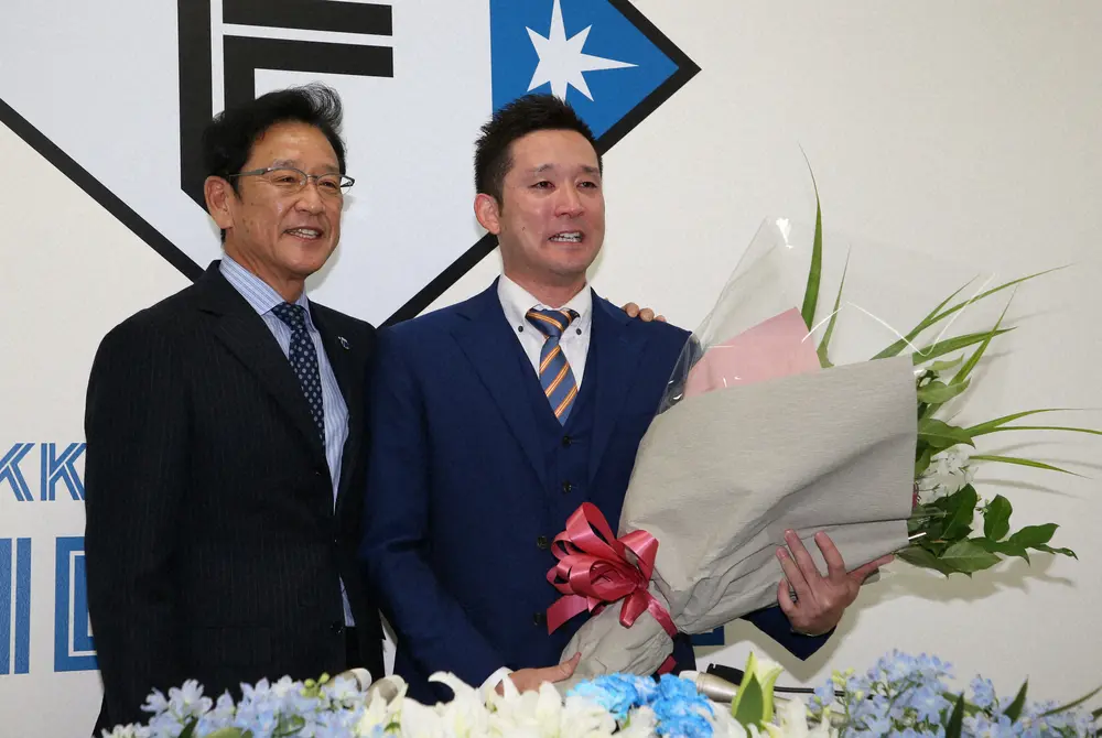 昨年の会見で侍ジャパン栗山監督（左）から花束を渡され、涙する杉谷氏