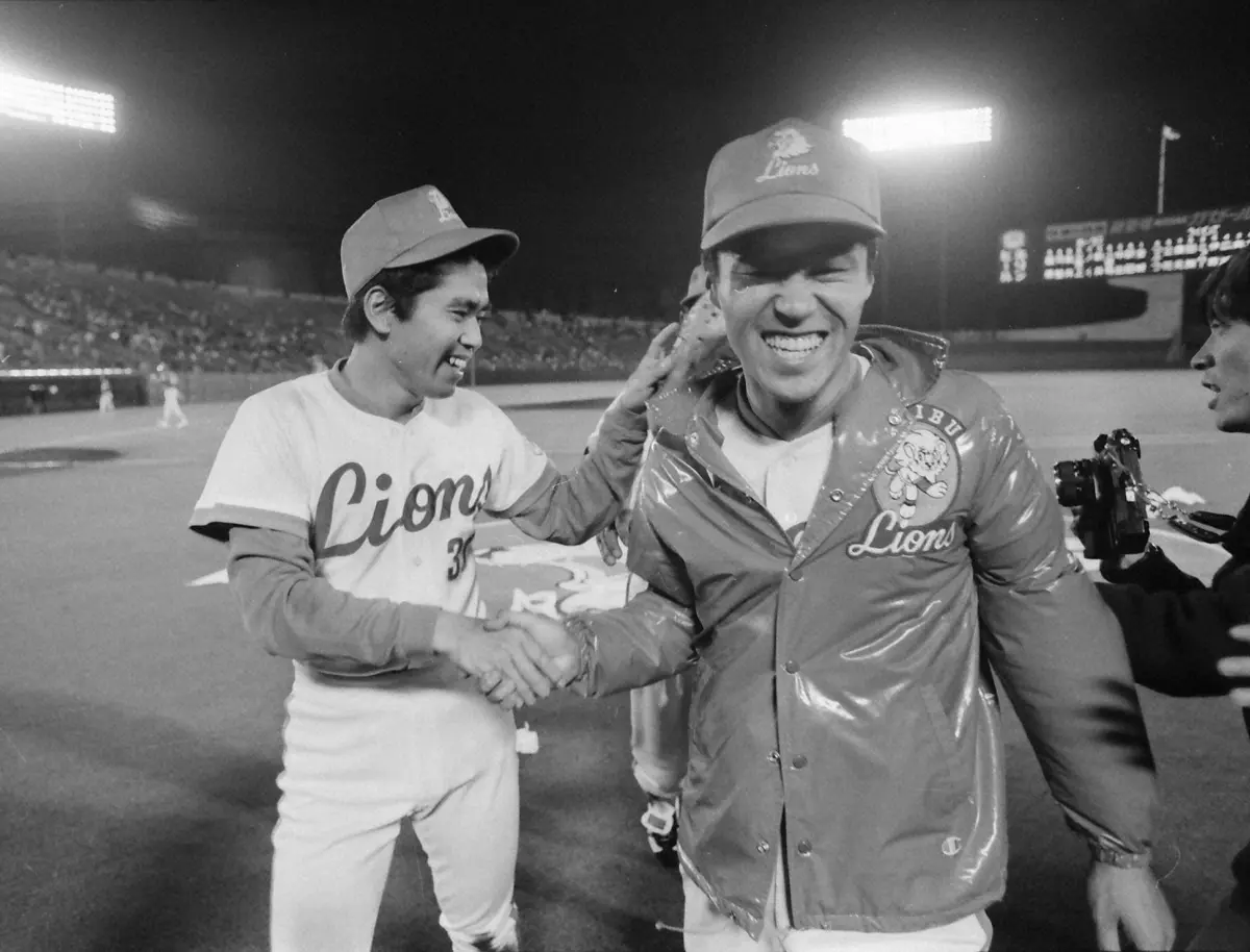 1979年4月24日、永射保（左）とがっちり握手を交わし笑顔を見せる松沼博久。記念すべき球団初勝利