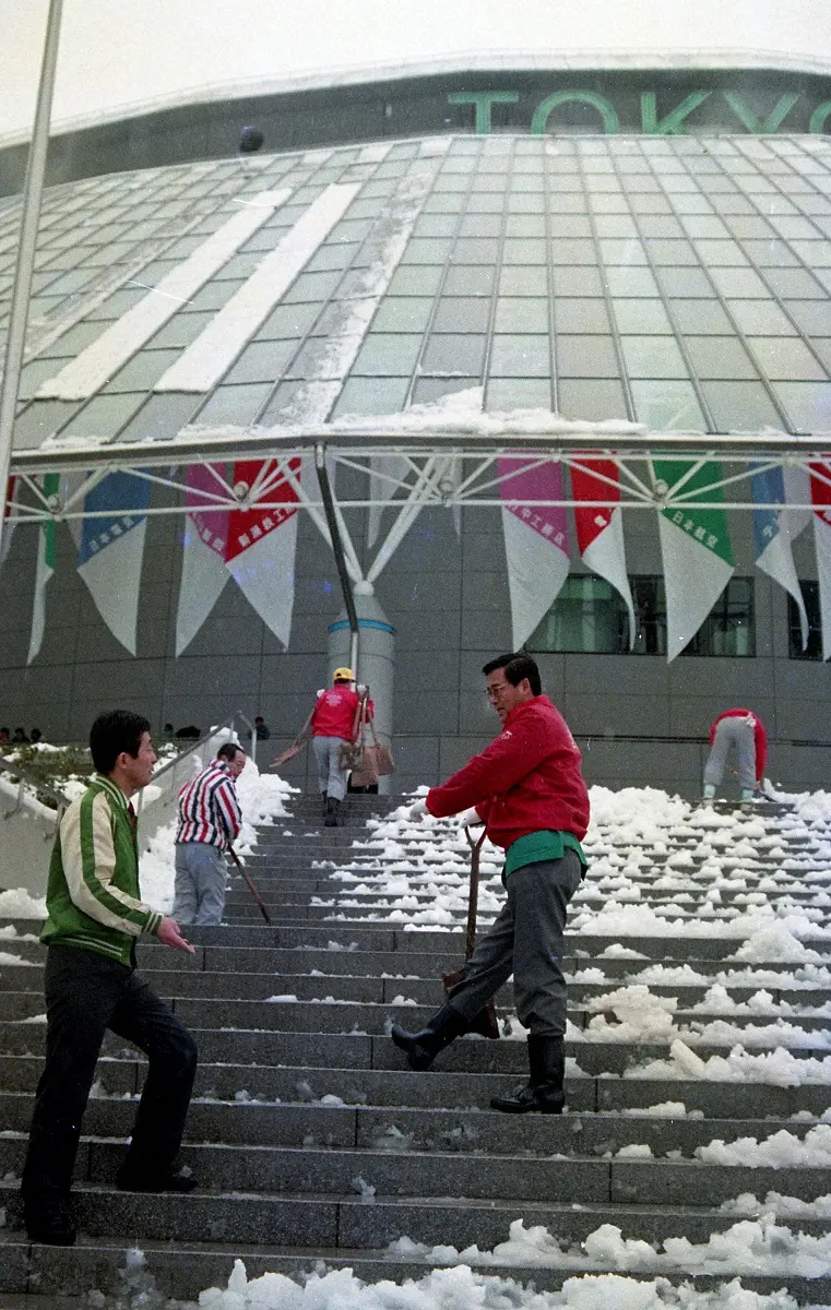 1988年4月8日、東京ドーム球場入口の雪かきを行う職員