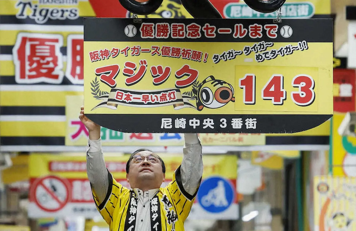 プロ野球阪神タイガースのセ・リーグ制覇を願い、「143」のマジックナンバーのボードを掲げる商店街関係者