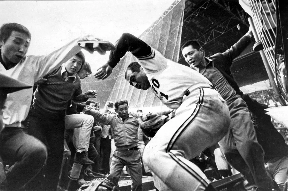 1973年10月22日、甲子園最終決戦で巨人がV９を飾ったが、ファンがグラウンドに飛び出し、この年３冠王の巨人・王貞治（右）が下駄で殴られる