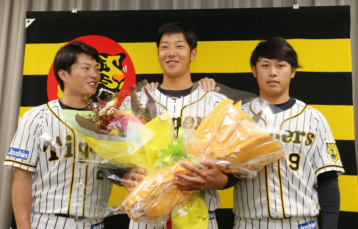 2019年、北條史也（左）と高山俊（右）から花束を手渡され、笑顔を見せる横田慎太郎氏