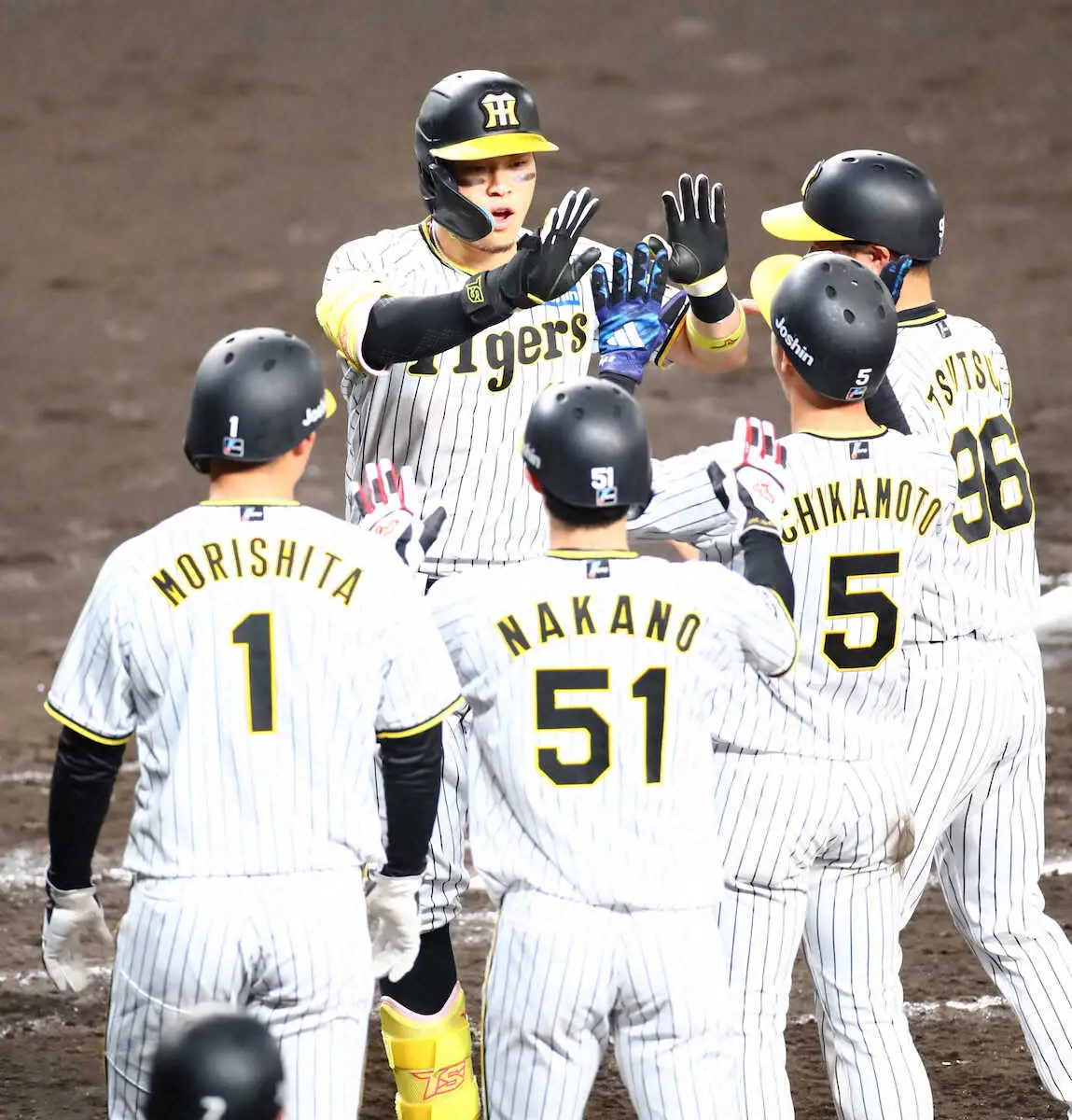 ＜神・巨＞　3回1死満塁、佐藤輝は右中間に先制の満塁本塁打を放ちナインに迎えられる　（撮影・後藤　大輝）　