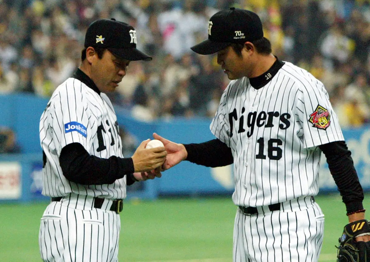 2005年、阪神・安藤優也投手（右）からウイニングボールを受ける岡田彰布監督