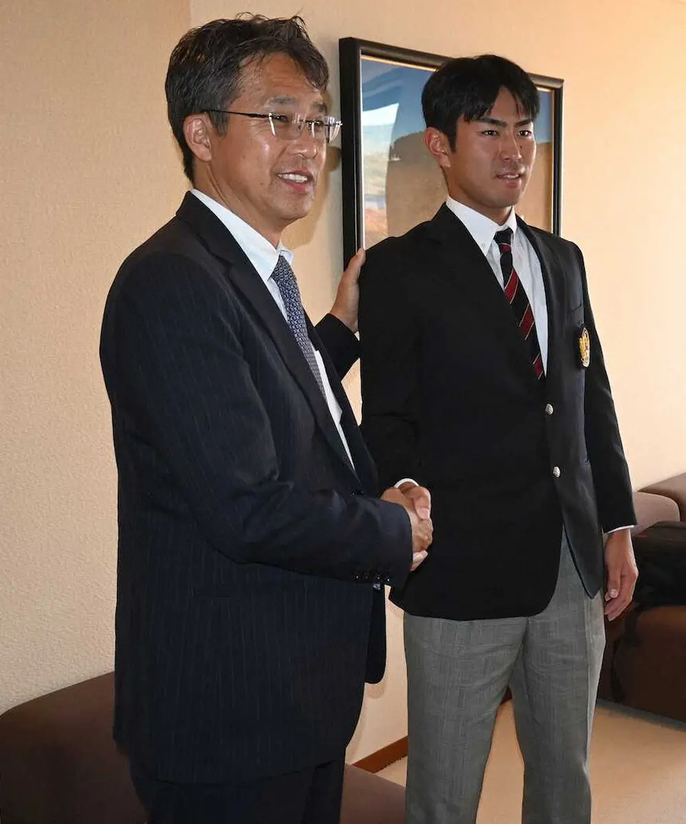 大渕スカウト部長（左）と握手を交わす宮崎（撮影・村井　樹）