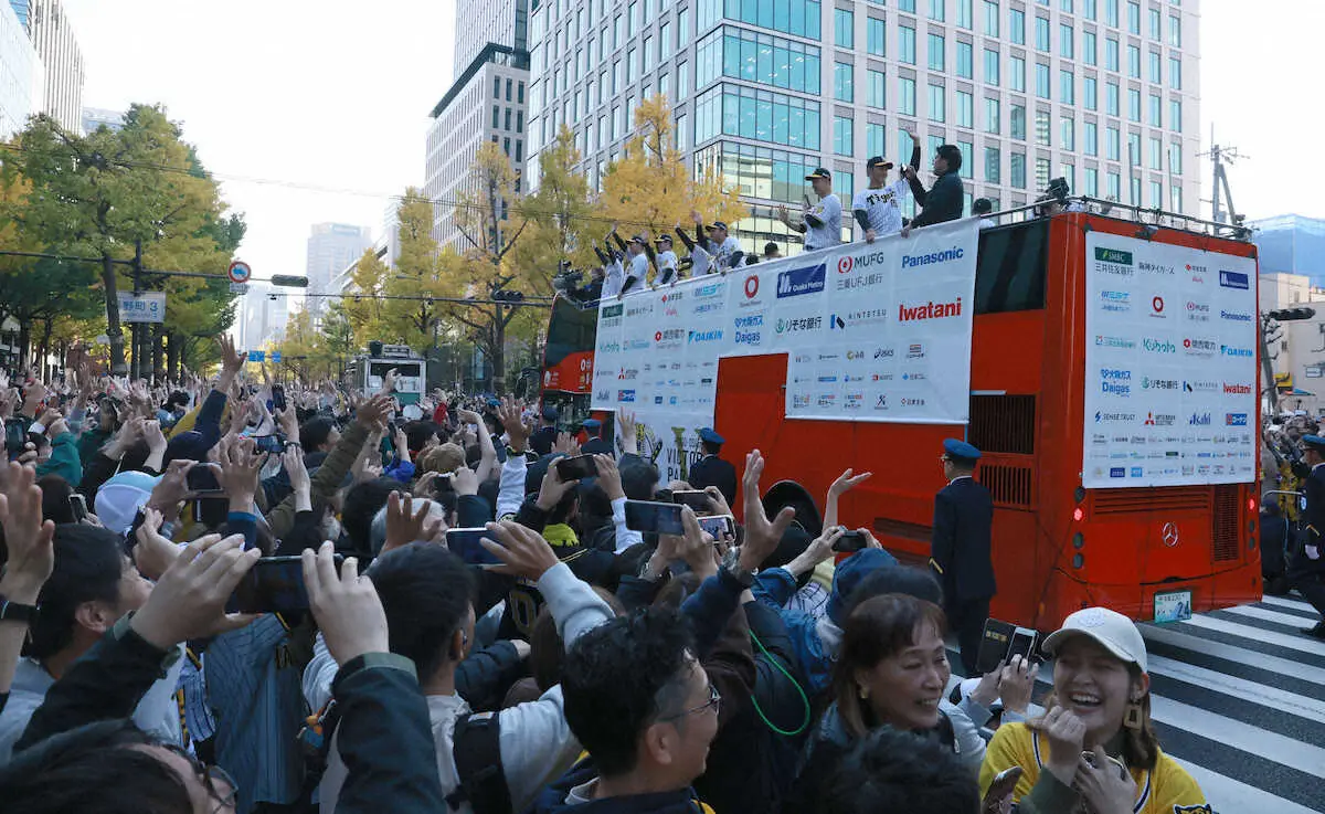 バスから大勢のファンに手を振り神戸をパレードする近本（左）、大山ら阪神ナイン（撮影・井垣　忠夫）