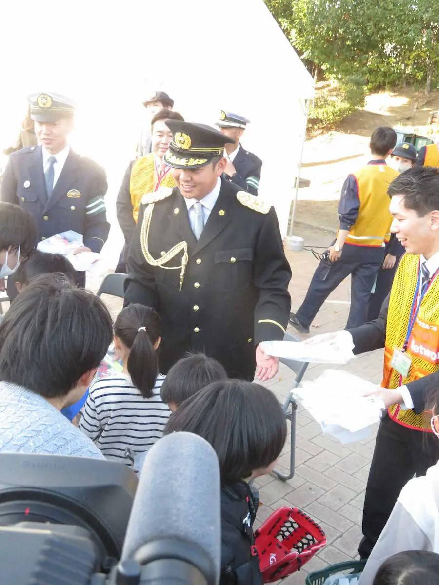 厚木署の1日警察署長を務めたDeNA山崎は少年ファンに交通安全の冊子を手渡す