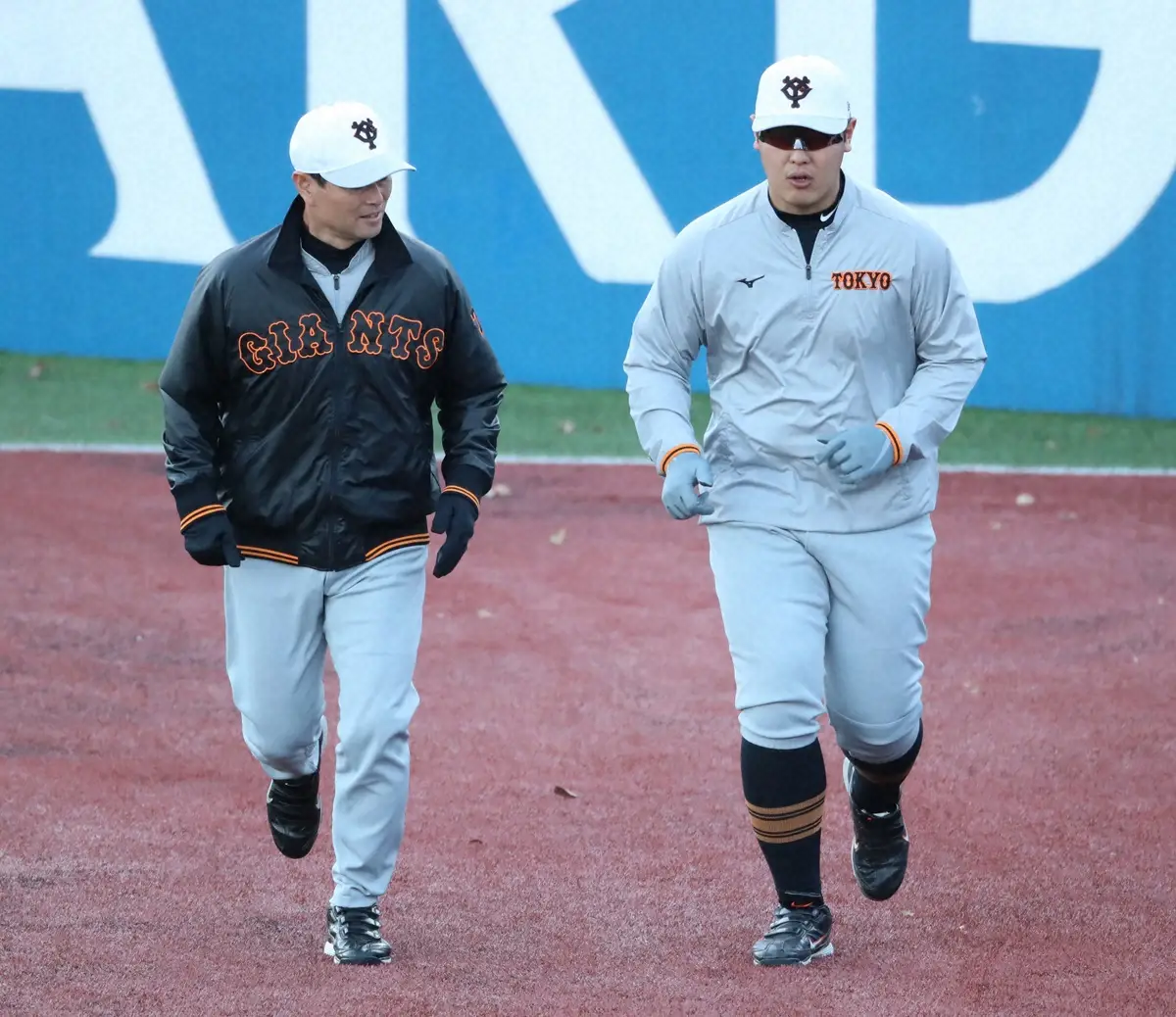 2021年、桑田コーチ（左）と話をしながらランニングをする岡本和真