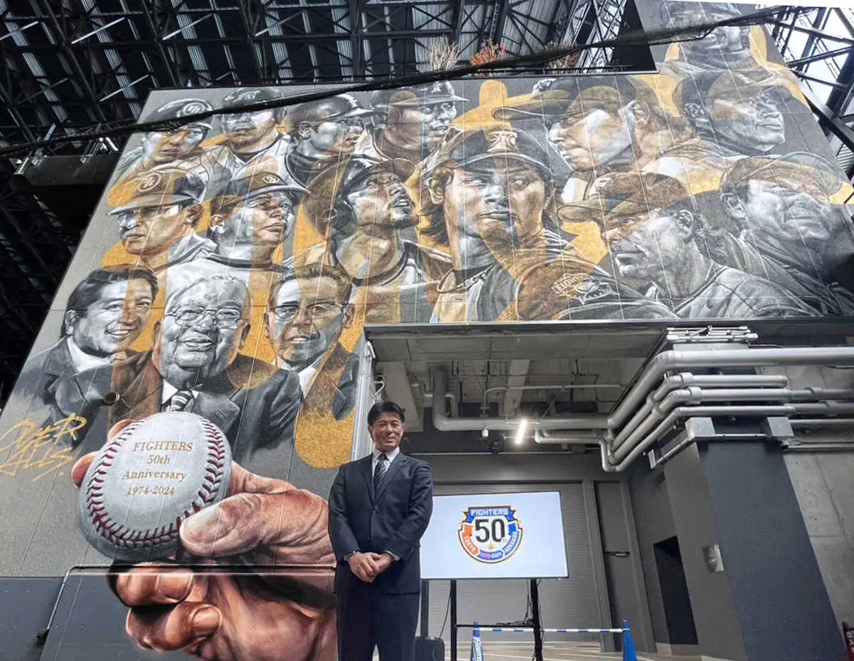球団創立50周年を記念した壁画の前で記念撮影する稲葉2軍監督