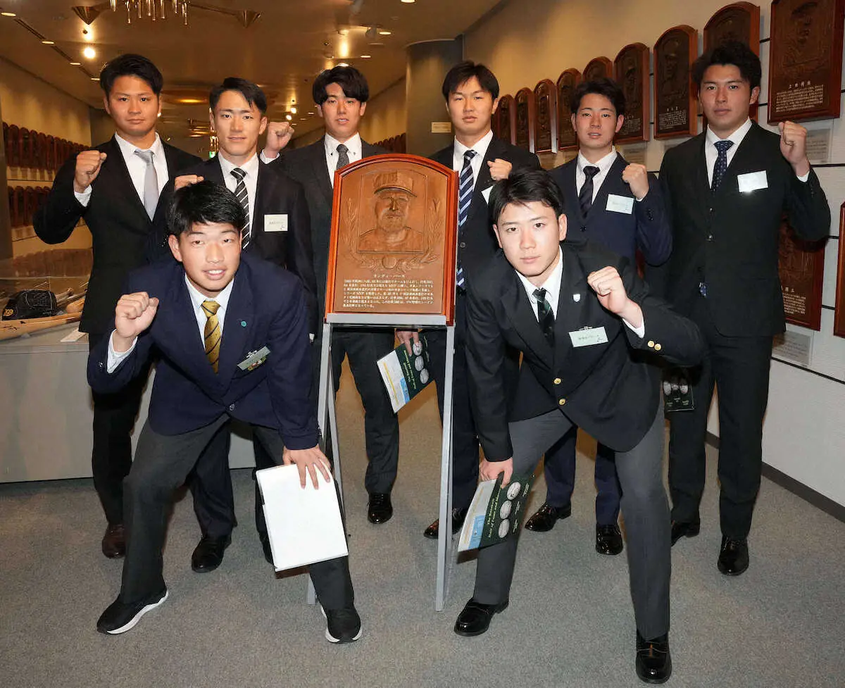 野球殿堂博物館を見学し、ランディ・バース氏のレリーフを囲み記念撮影する下村海翔（後列右から2人目）ら阪神の新人選手たち