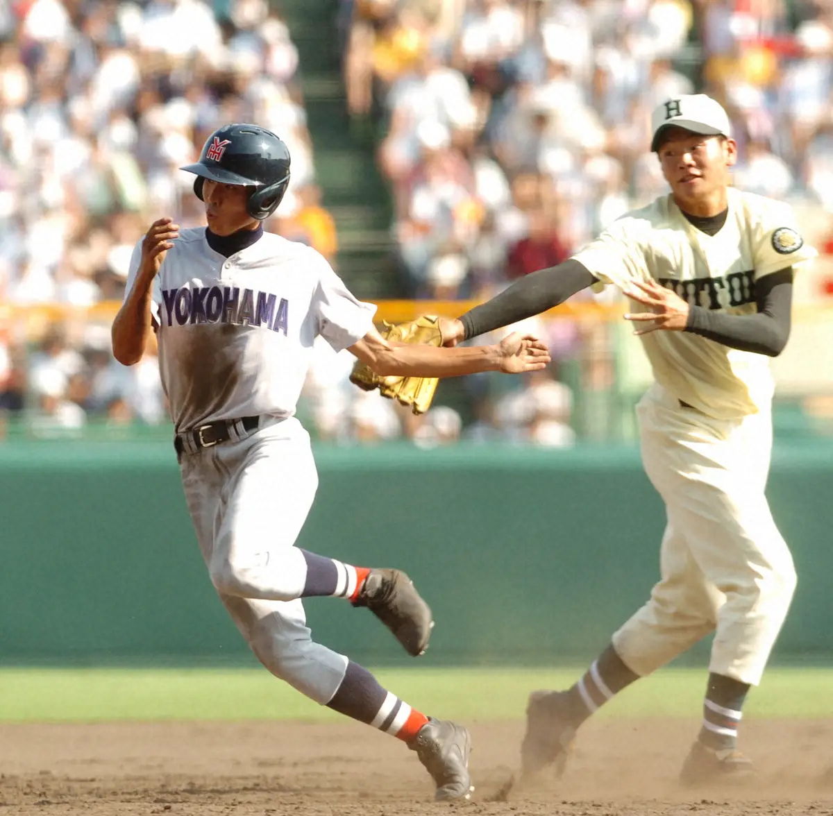 2013年夏の甲子園1回戦・報徳学園戦で相手タッチをくぐり抜け三塁へ進塁する横浜・二塁走者の石川雄洋内野手（左）。