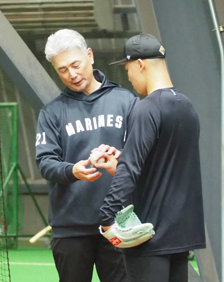 菊地（右）にフォークボールの握りを伝授するロッテ・吉井監督