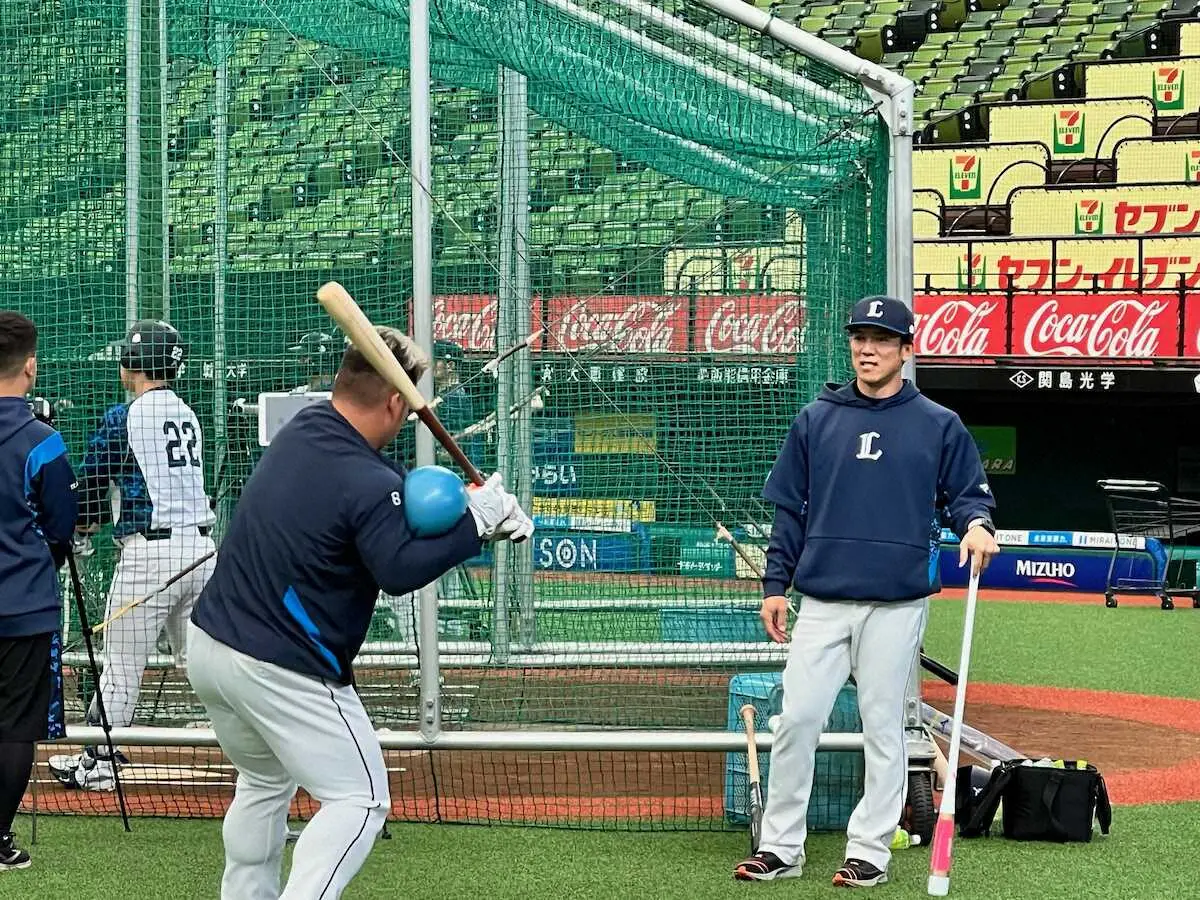 西武・松井監督（右）は渡部に、右肘にトレーニング用のボールを挟む打撃練習を指導