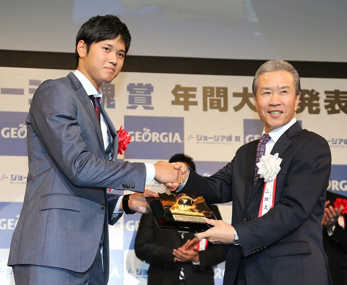 2014年11月、ジョージア魂賞年間大賞を受賞し、選考委員を務めた山田久志氏（右）から盾を受け取る日本ハムの大谷翔平