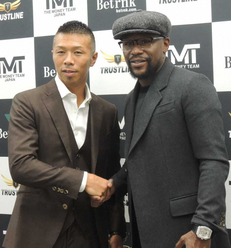 写真撮影に応じた元WBA世界スーパーフェザー級王者・内山高志氏（左）と握手を交わす元5階級制覇王者フロイド・メイウェザー