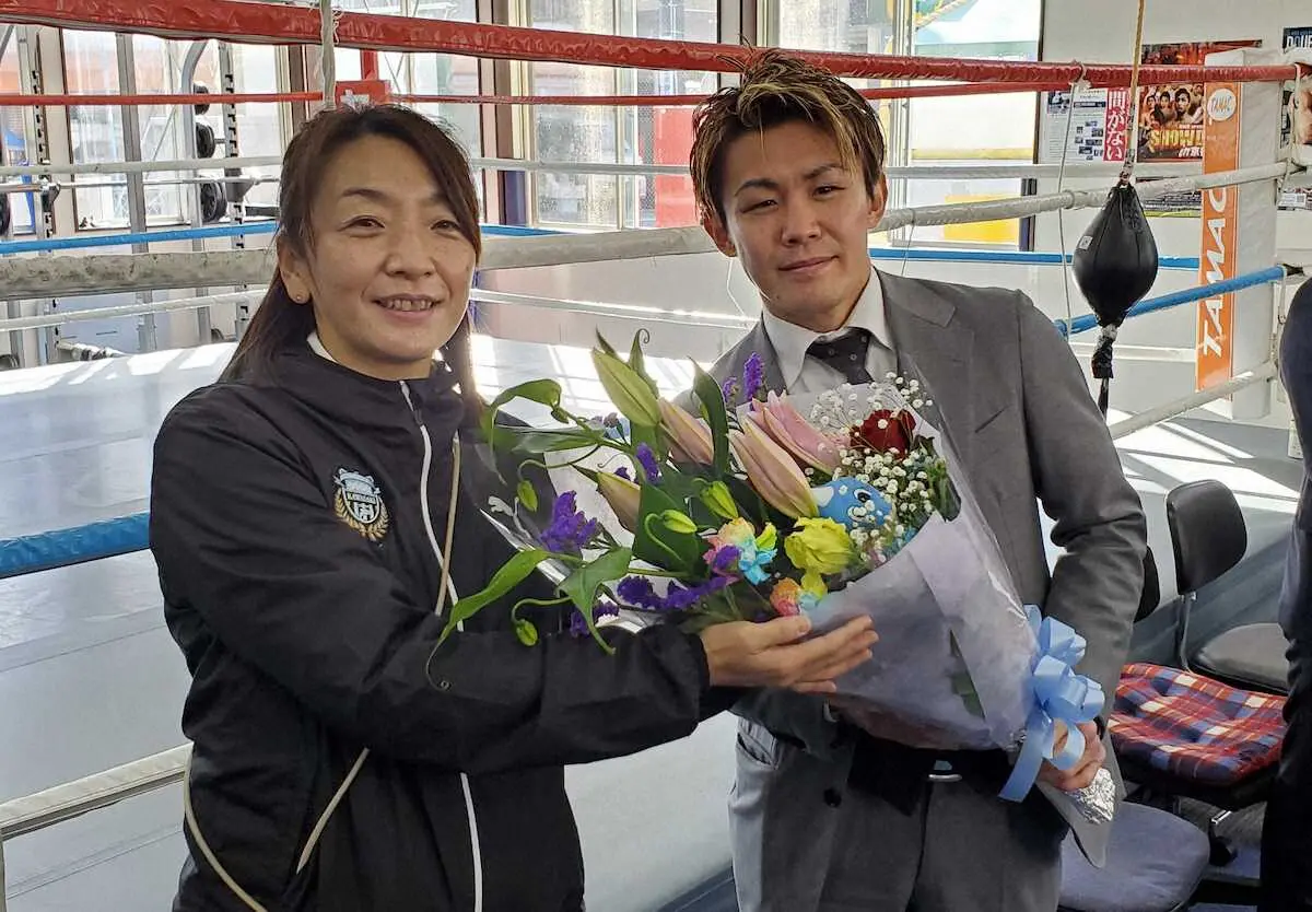 引退を発表した古橋岳也（右）は川崎Fプロモーション担当の加藤祐美子さんから花束を受け取る