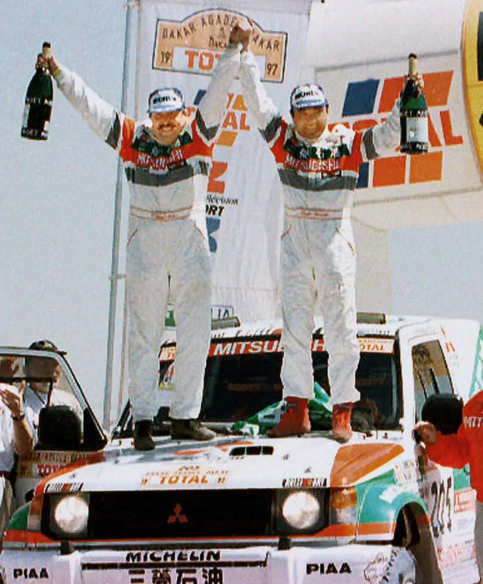 97年、ダカール・ラリーで総合優勝を果たした篠塚建次郎さん(右、AP)