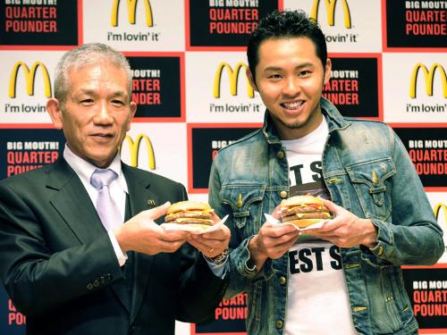 日本マクドナルドの商品発表会で、大形ハンバーガー「クォーターパウンダー」を手にする競泳の北島康介選手（右）と原田泳幸会長兼社長