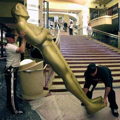 ２０日、米ロサンゼルスで開かれるアカデミー賞の授賞式の会場入り口にオスカー像を設置する作業員