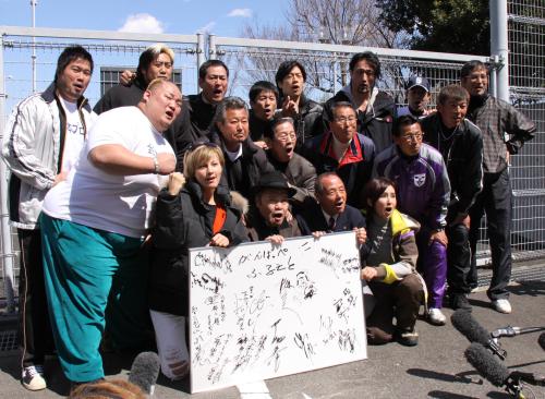 「がんばっぺ！！ふるさと」の寄せ書きを手に被災者にエールを送る西田敏行（前列左から２人目）ら参加者