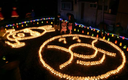 やなせたかしさんを追悼し、灯がともされたアンパンマンと「やなせ兎」をかたどったキャンドル＝14日夜、高知県南国市