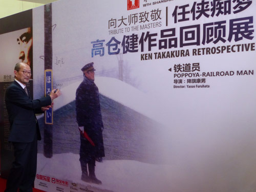 上海国際映画祭で始まった「高倉健トリビュート上映会」の会場に設置されたパネルにサインする降旗康男監督