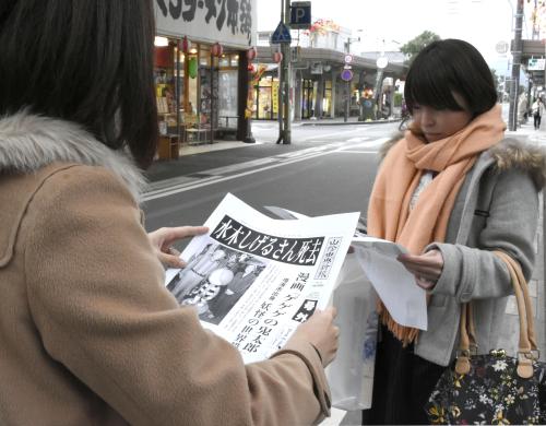 鳥取県境港市の「水木しげるロード」で、号外を読む観光客