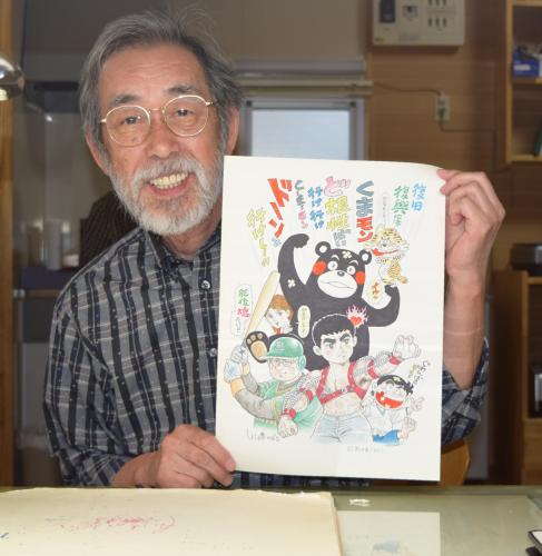 川崎のぼる氏は描きあげた「くまモン頑張れ絵」を手に笑顔