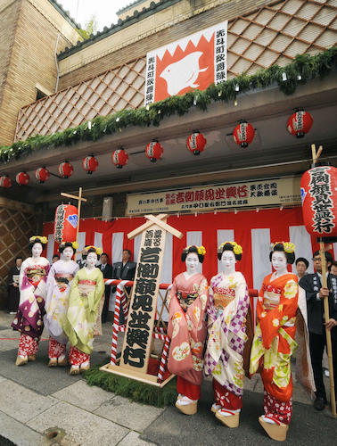 京都・先斗町歌舞練場前で「吉例顔見世興行」の看板を囲む舞妓たち