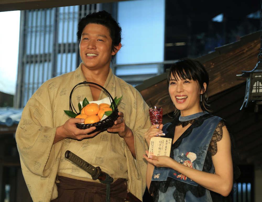 交換したみかんと薩摩切子を手に笑顔を見せる鈴木亮平（左）と柴咲コウ