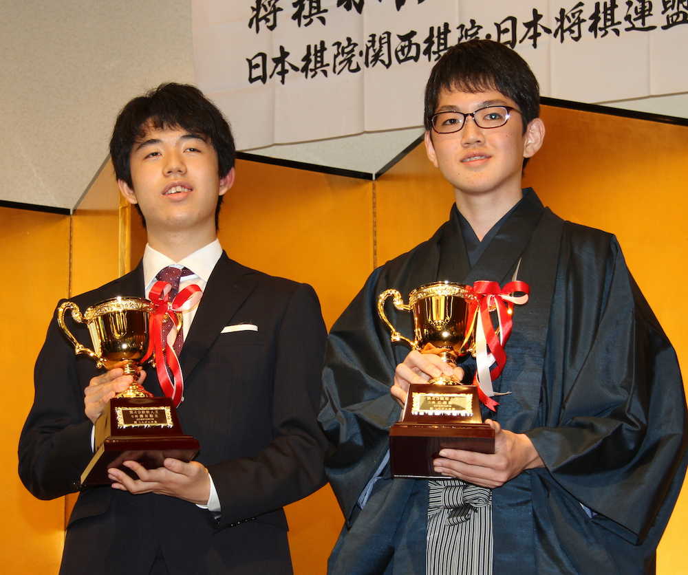 囲碁の新人王・広瀬優一・二段（左）とともにトロフィーを手にする藤井聡太七段