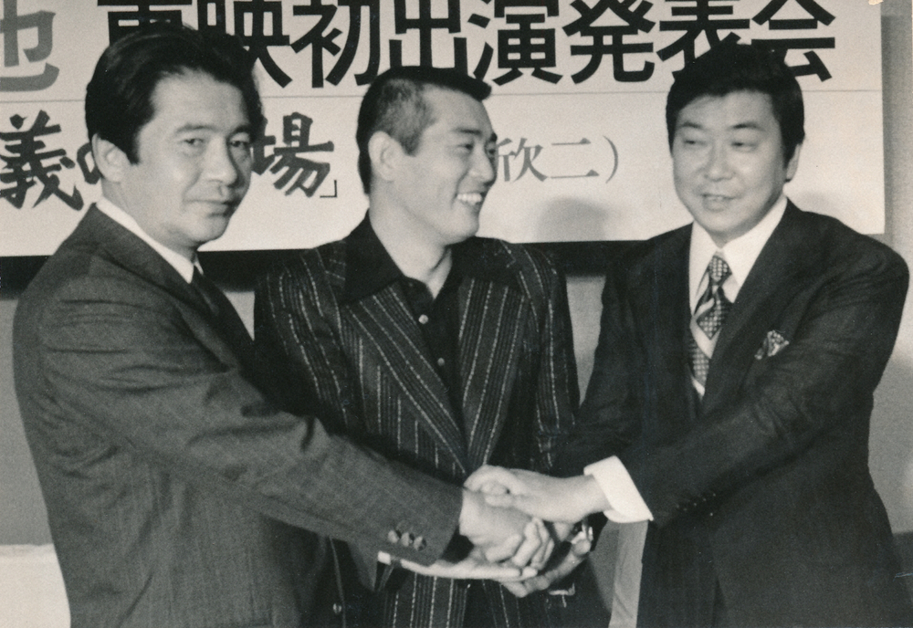 「仁義の墓場」出演発表会で手を取り合う（左から）岡田社長、渡哲也さん、石原裕次郎さん