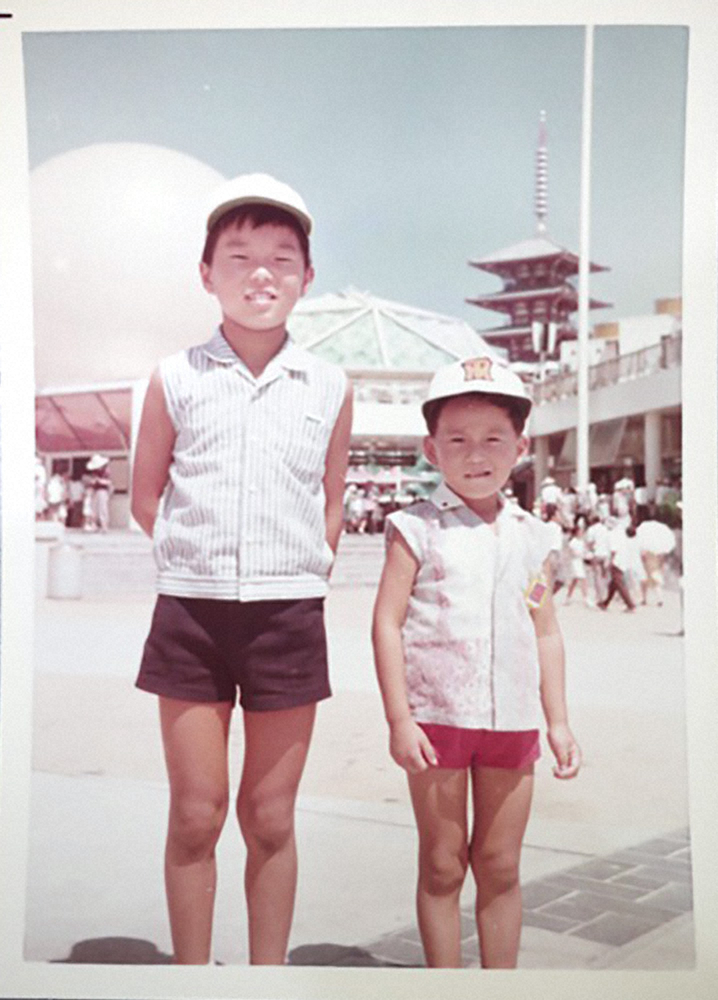 ７０年の大阪万博でお兄さんとポーズをとる５０年前のシマダタモツさん（右）。まさに珍宝です！