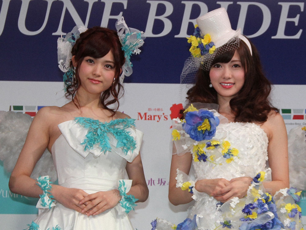 2014年6月、イベントにウェディングドレス姿で登場する松村沙友理（左）と白石麻衣