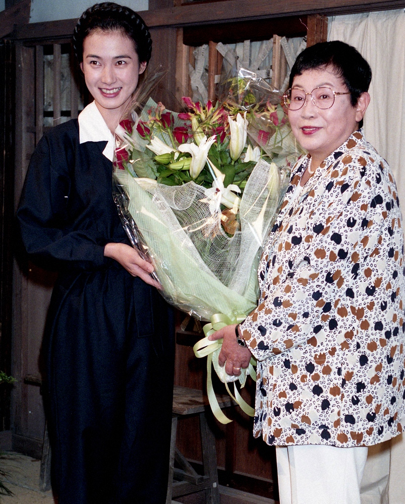 <NHK「春よ、来い」>　製作発表会　脚本の橋田寿賀子さん（右）から激励の花束を受けとり、笑顔を見せる安田成美　1994年9月17日付紙面より
