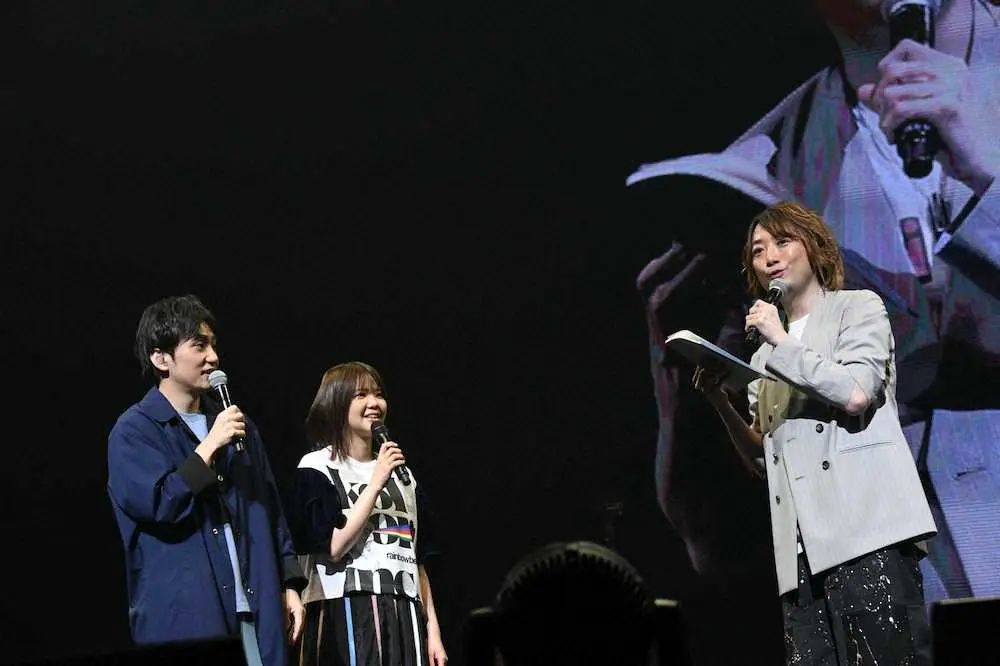 いきものがかりの横浜アリーナ公演で、水野良樹（左）から贈られた日記のノートを手にする山下穂尊。左から2人目は吉岡聖恵