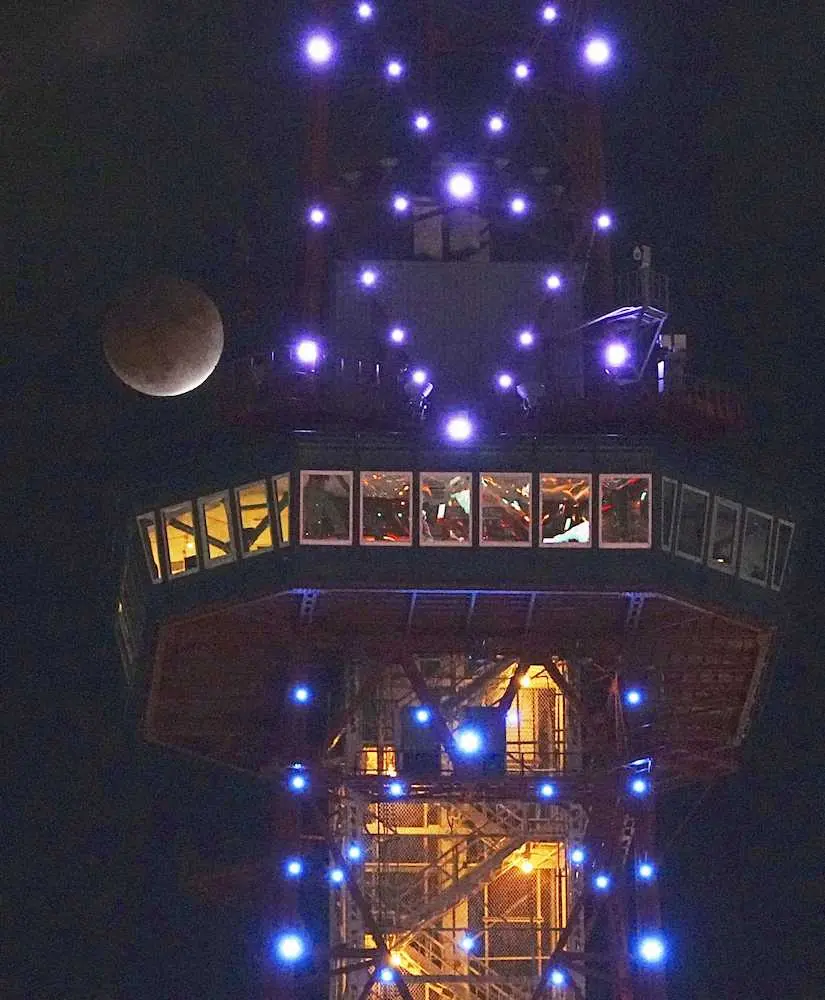 19日午後6時2分、札幌市で見られた部分月食。右はさっぽろテレビ塔