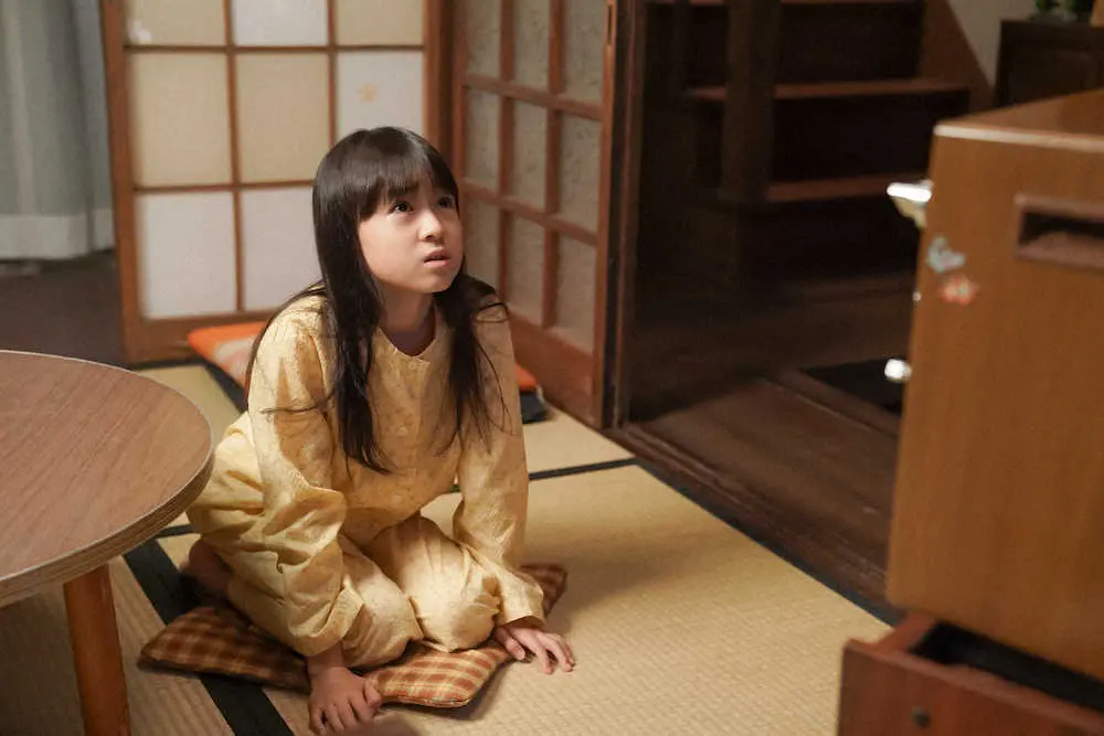 連続テレビ小説「カムカムエヴリバディ」で、茶の間のテレビの前に座る、ひなた（新津ちせ）（C）NHK
