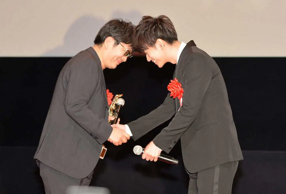 第76回毎日映画コンクール表彰式　「TSUTAYA映画ファン賞」を受賞し、大友啓史監督（左）とおでこを合わせるように握手する佐藤健