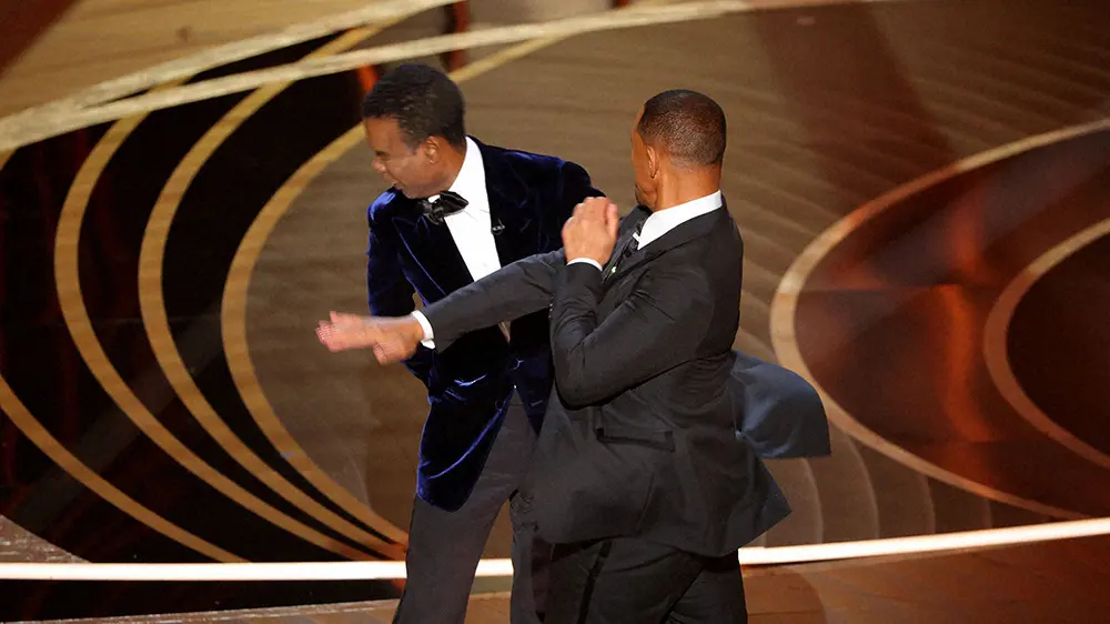 米アカデミー賞の授賞式でクリス・ロック（左）を殴るウィル・スミス（ロイター）