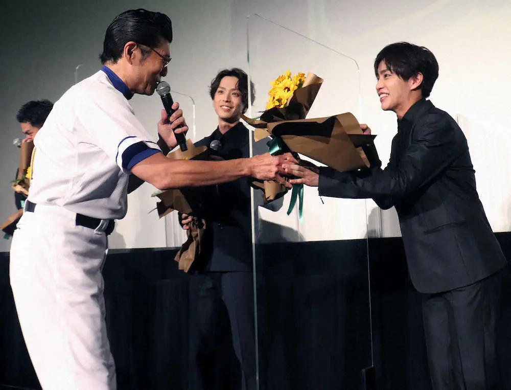 映画「野球部に花束を」の公開記念舞台あいさつで、醍醐虎汰朗（右）に花束を渡す高嶋政宏（左）