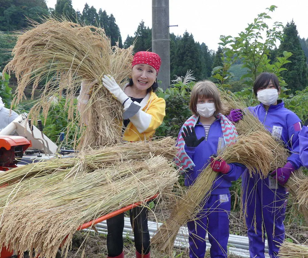 新潟県長岡市の山古志地域の「小林幸子田」で収穫された稲の脱穀作業を行った小林幸子。山古志小学校の児童と。