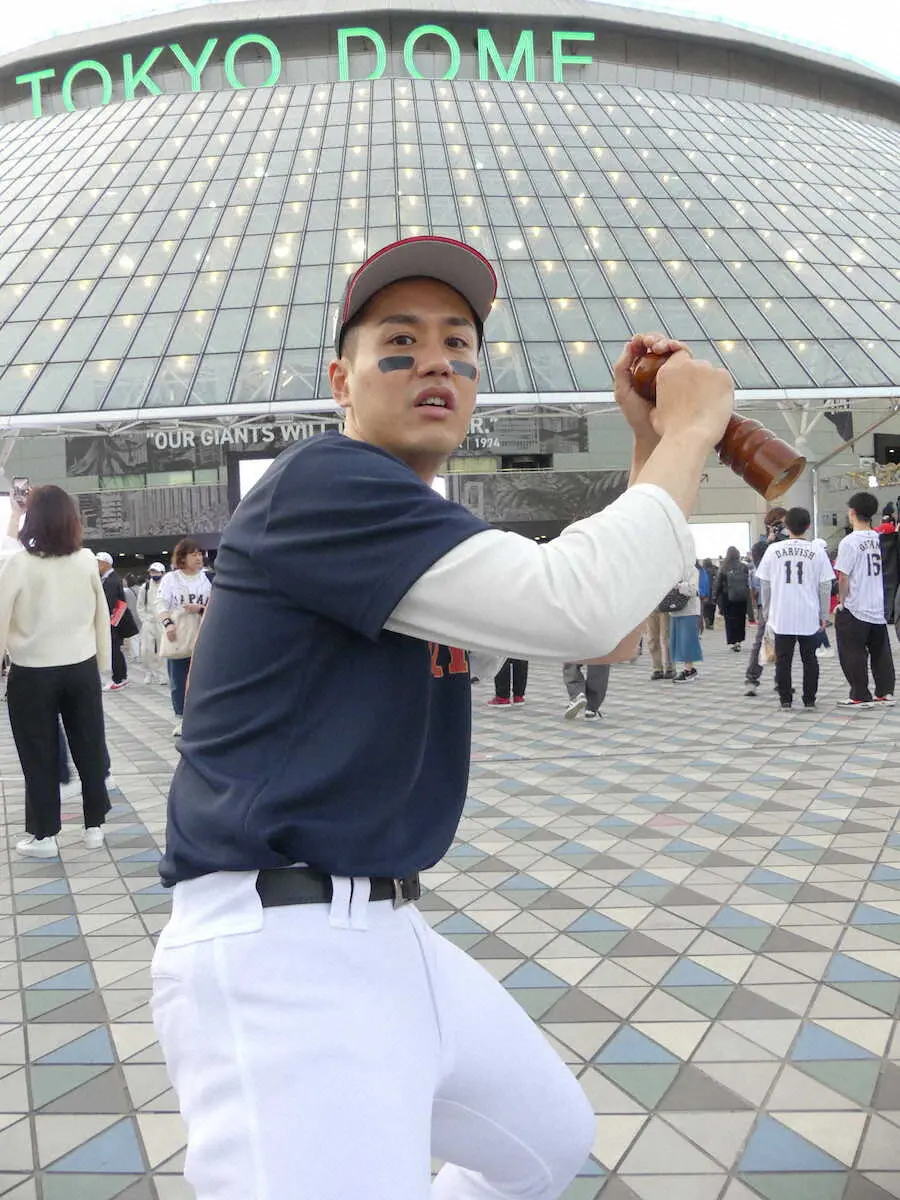 東京ドーム前を訪れたヌートバー似と話題の「双六人間」石川ひろし。ペッパーミルを手に打撃の構えをまねる