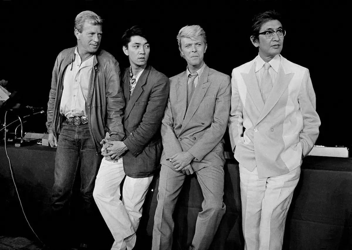 パリで、映画「戦場のメリークリスマス」の大島渚監督（右端）や出演したデビッド・ボウイさん（右から2人目）と記念撮影する坂本龍一さん（左から2人目）＝1983年5月（AP）