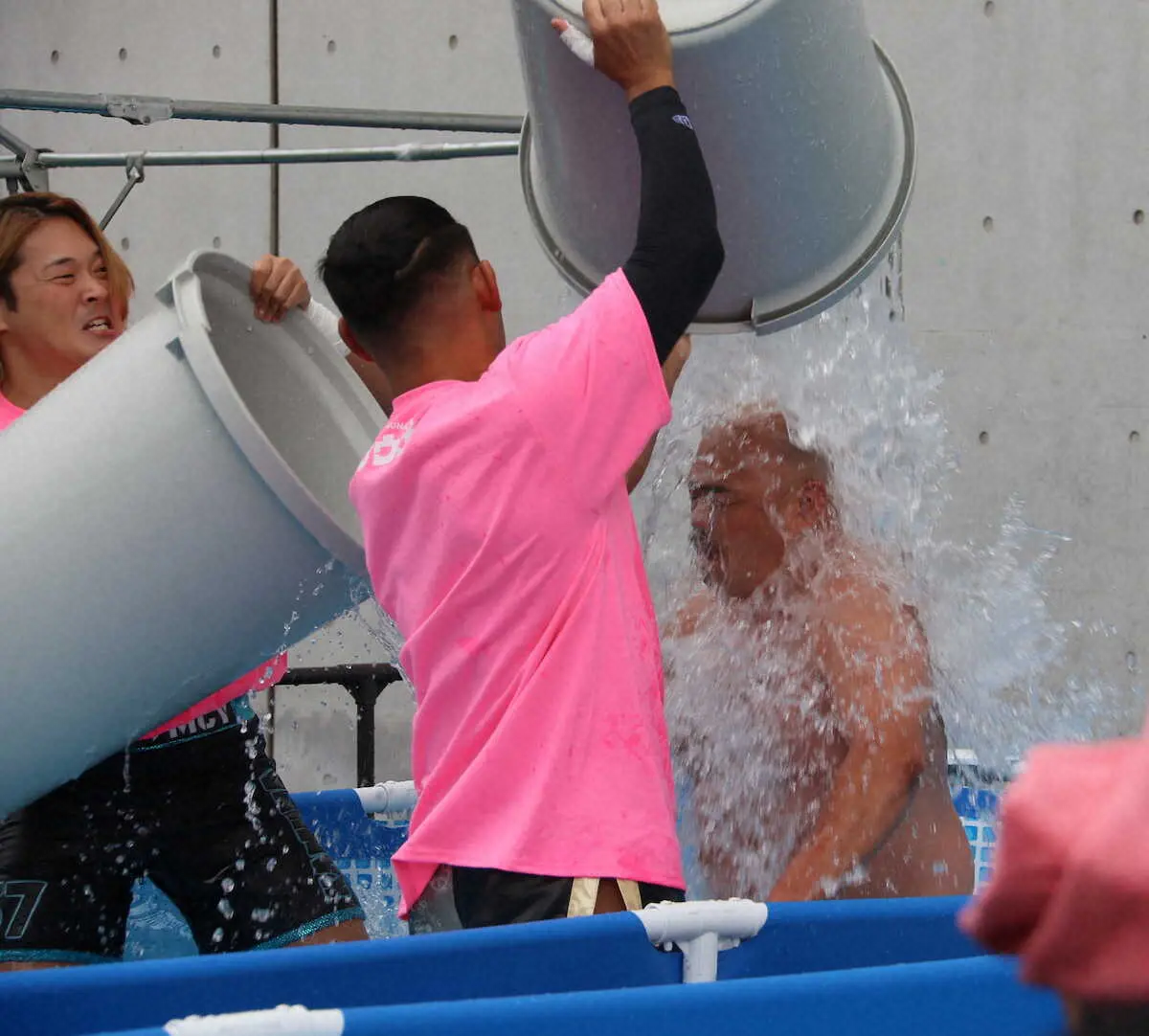 ＜ニコニコ超会議＞DDTの選手たちから水をかけられるクロちゃん（右）
